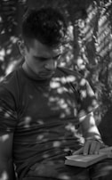 A person enjoying a quiet moment while reading outdoors.