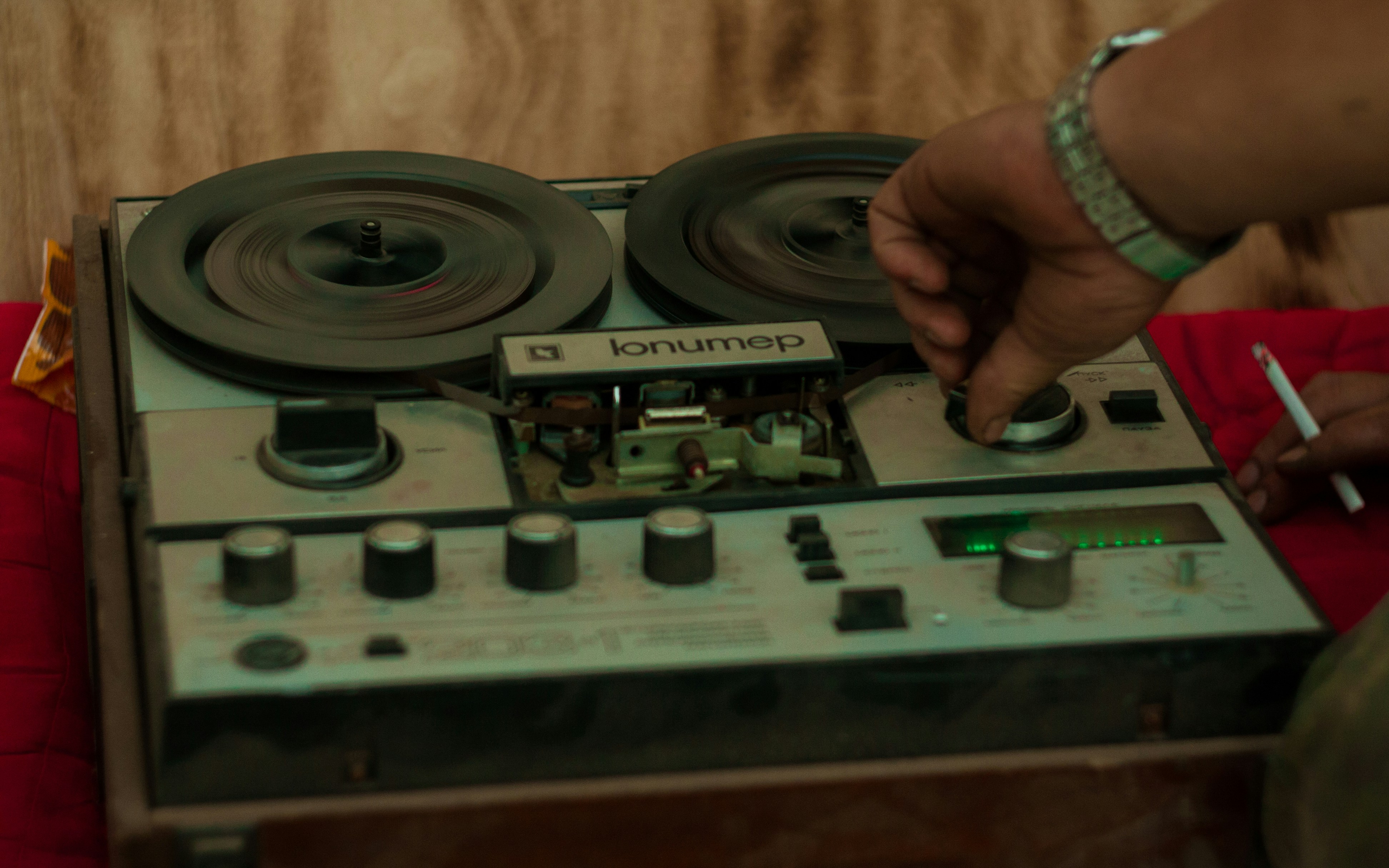 una persona sosteniendo un cigarrillo frente a una radio