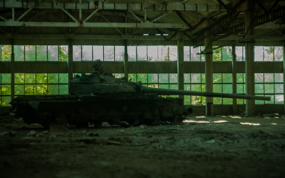 um tanque está sentado em um prédio abandonado