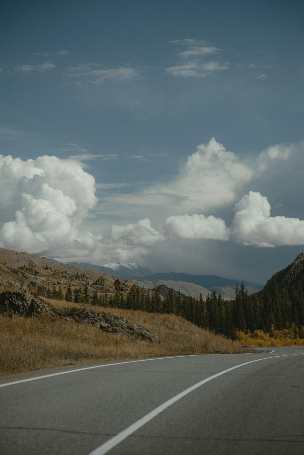 a car driving down a road with mountains in the background