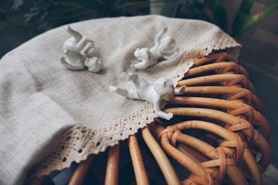 Delicate vintage porcelain figurines displayed on a glass cabinet, bathed in soft natural light.