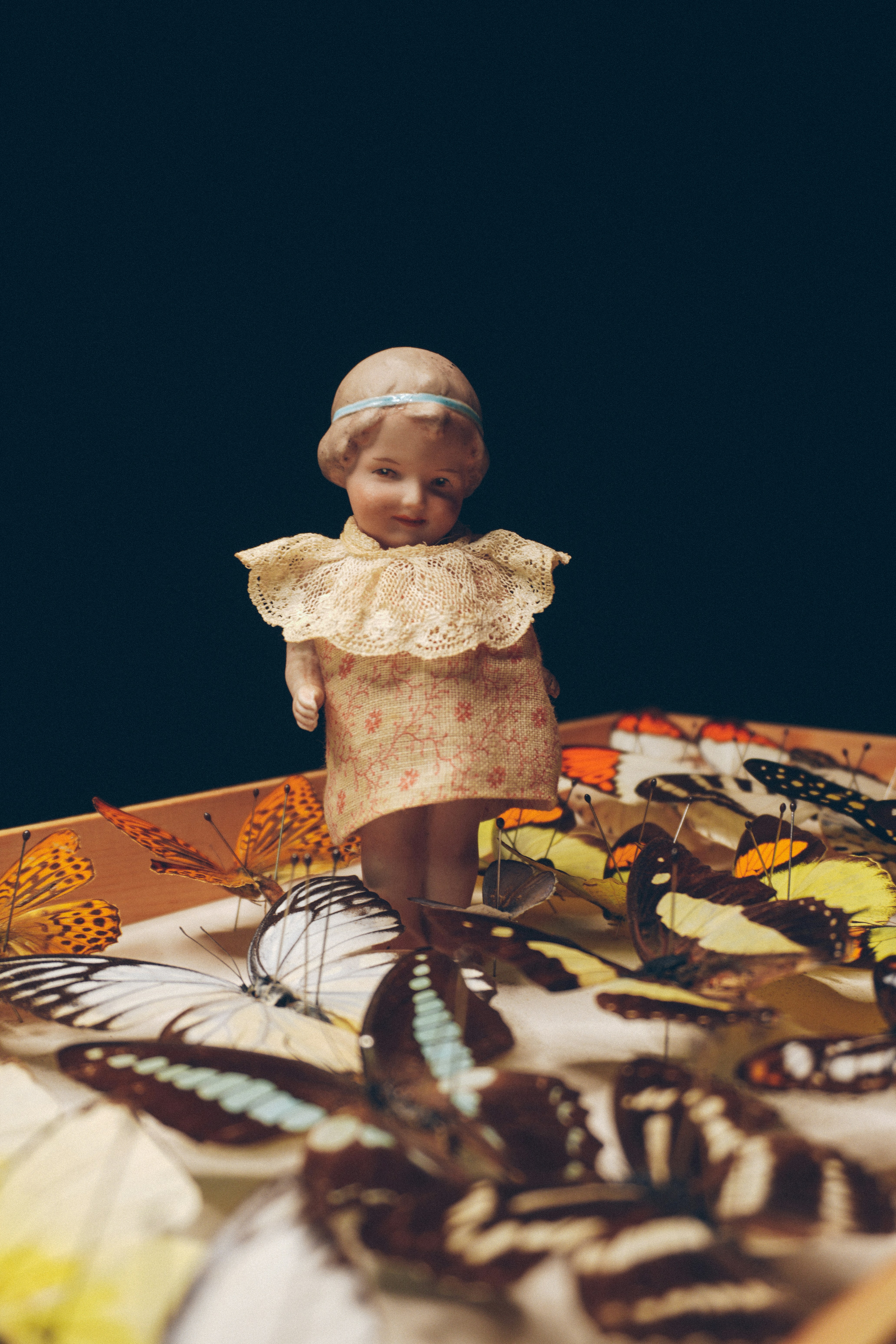 a doll standing on top of a table filled with butterflies