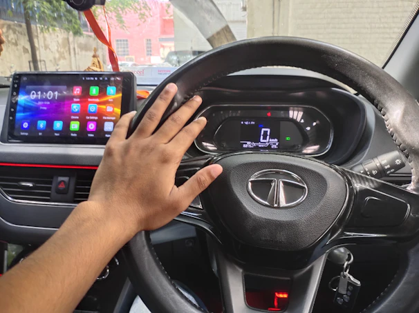 A happy user unlocking a sleek car through the Veloce app on their smartphone.