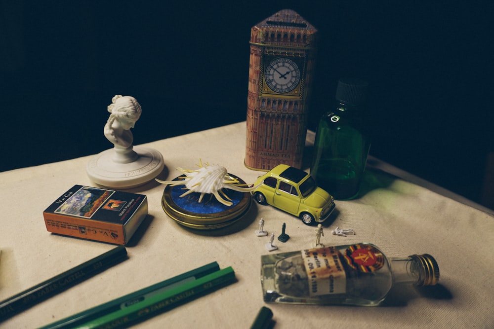 a table topped with a bottle of liquor and a clock tower