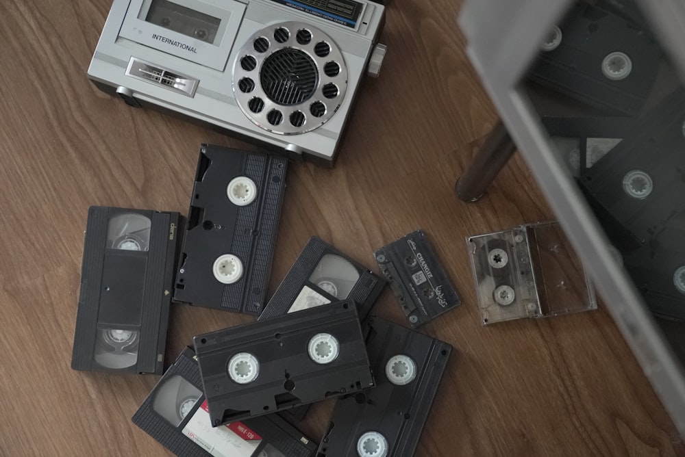 a pile of old tape recorders sitting on top of a wooden floor