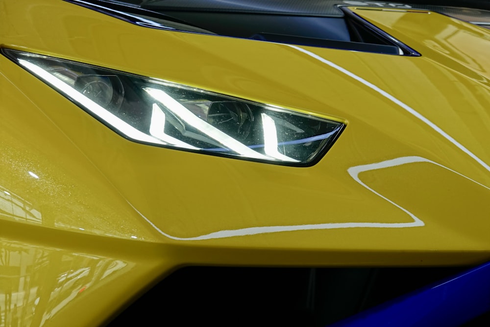 a close up of the front of a yellow sports car