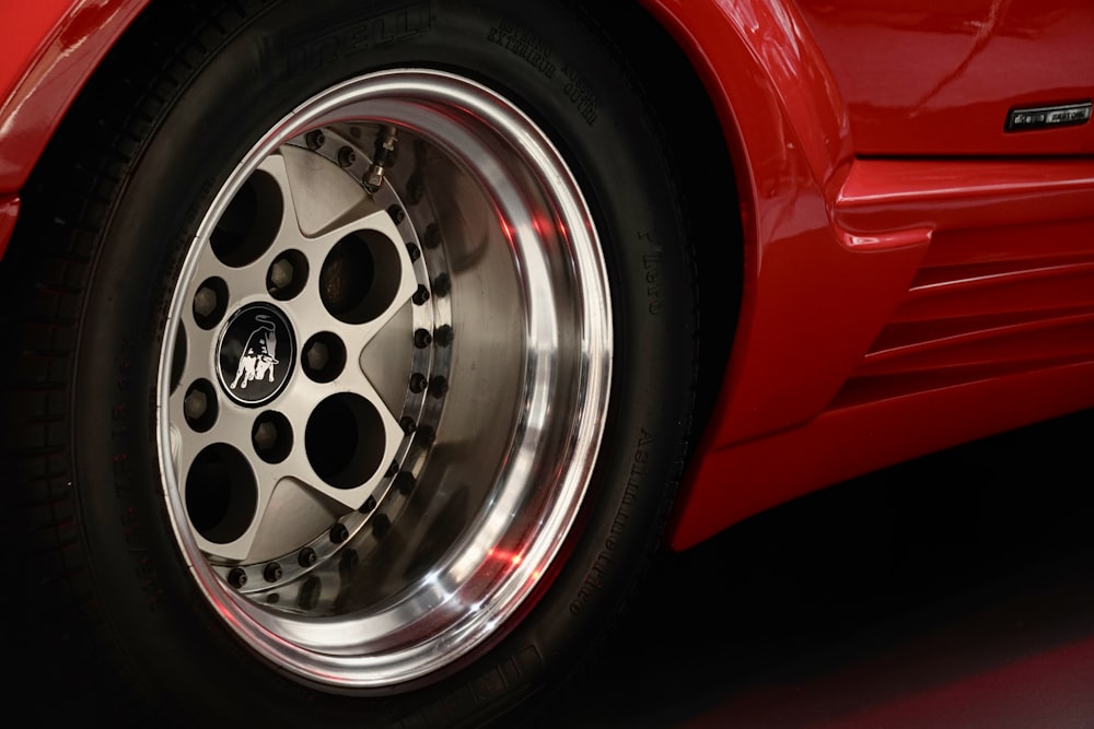 a close up of a red sports car wheel