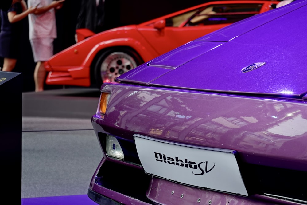 a purple sports car is on display at a car show
