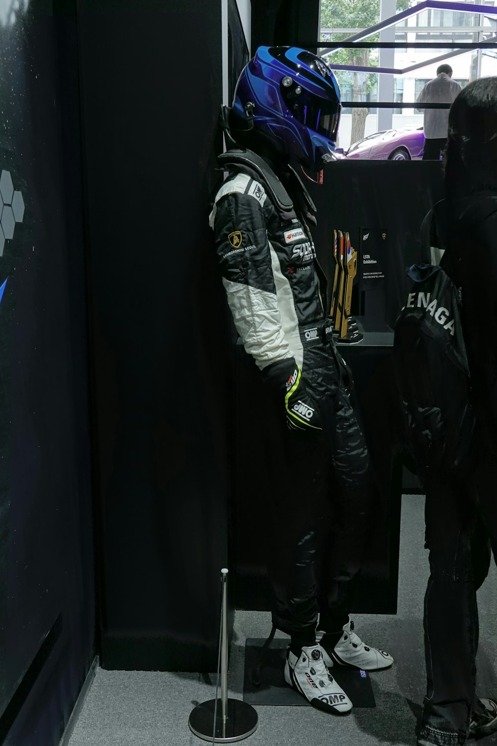 a man in a racing suit standing next to another man