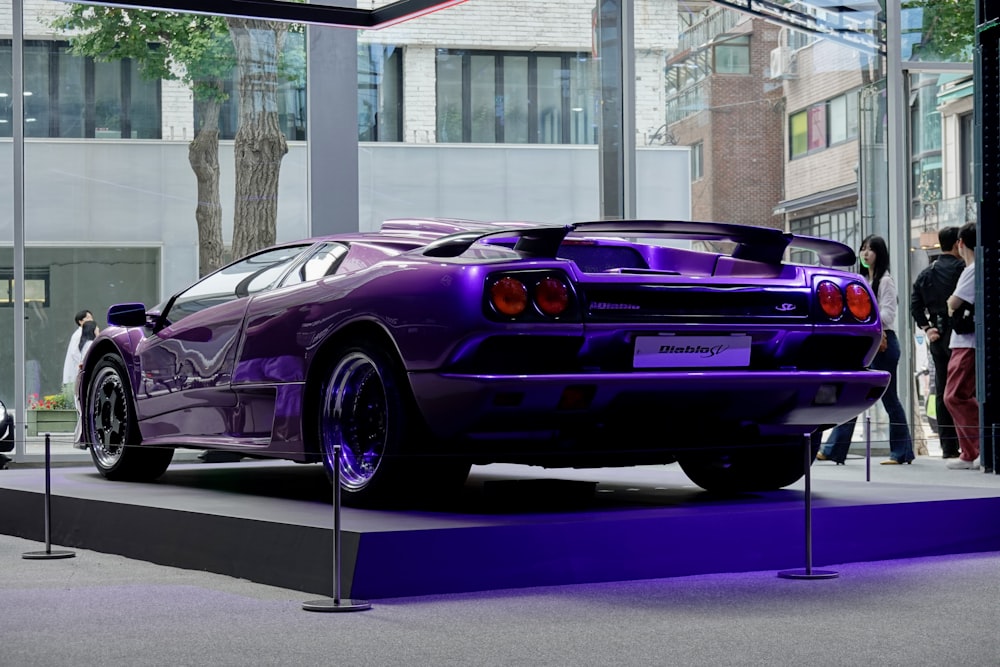 a purple sports car on display at a car show