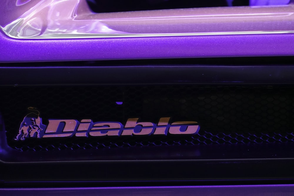 a close up of a purple car with a logo on it