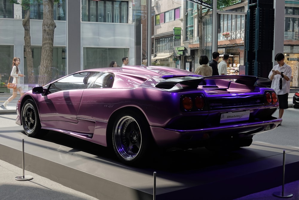 a purple sports car is on display on a city street