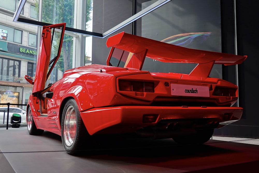 a red sports car parked in front of a tall building