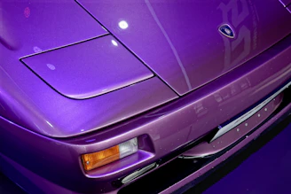 Close-up of a freshly detailed car hood gleaming under the sun with a hint of purple reflection.