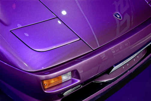 Close-up of a freshly detailed car hood gleaming under the sun with a hint of purple reflection.