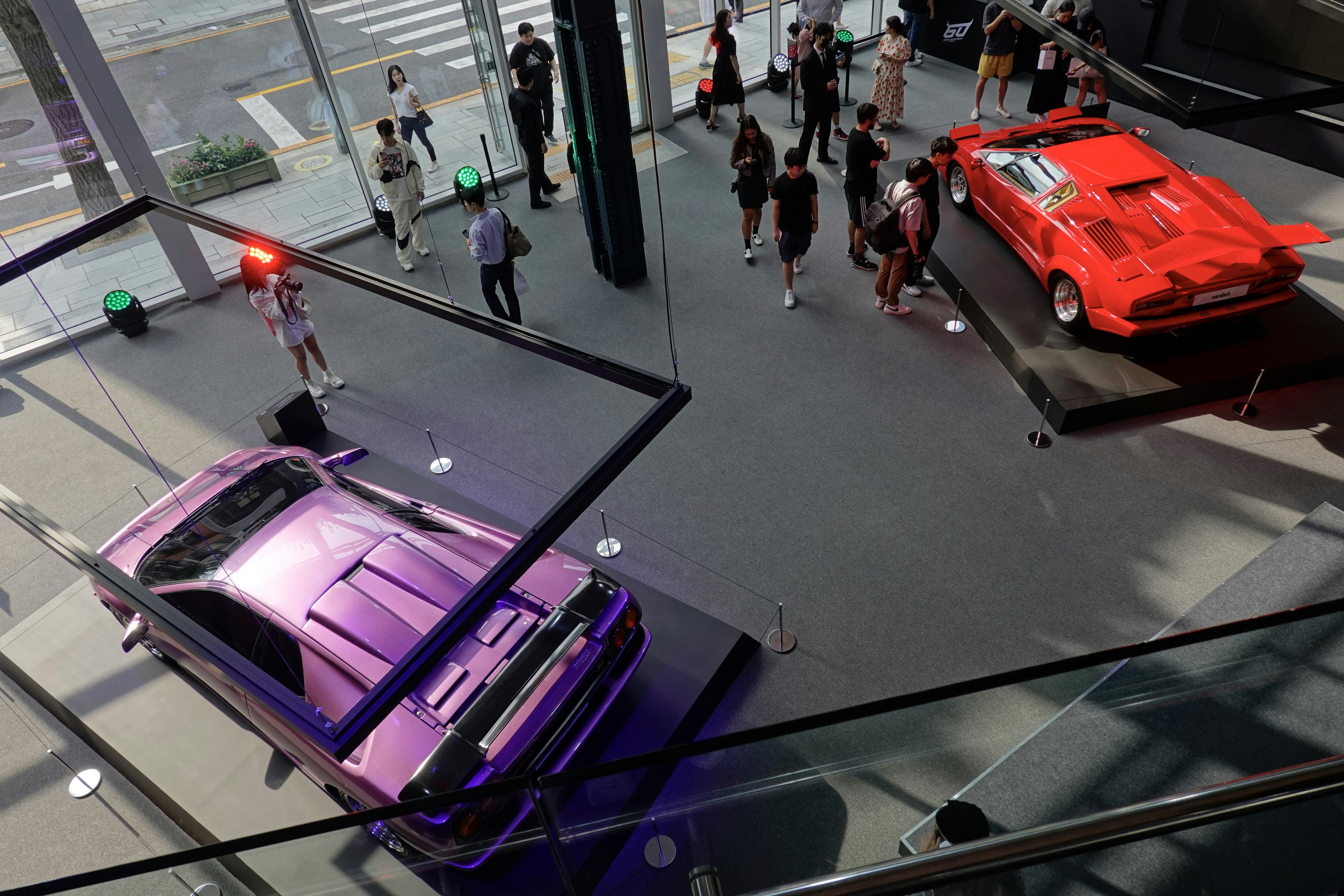 a group of people standing around a purple car