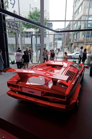 a red sports car on display in a building