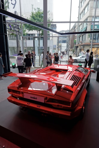 a red sports car on display in a building