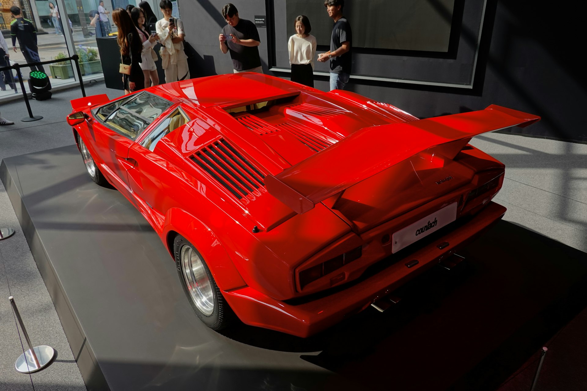 a red sports car is on display in a museum
