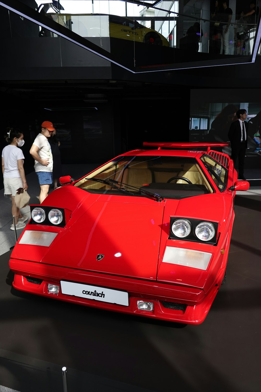 a red sports car on display at a car show