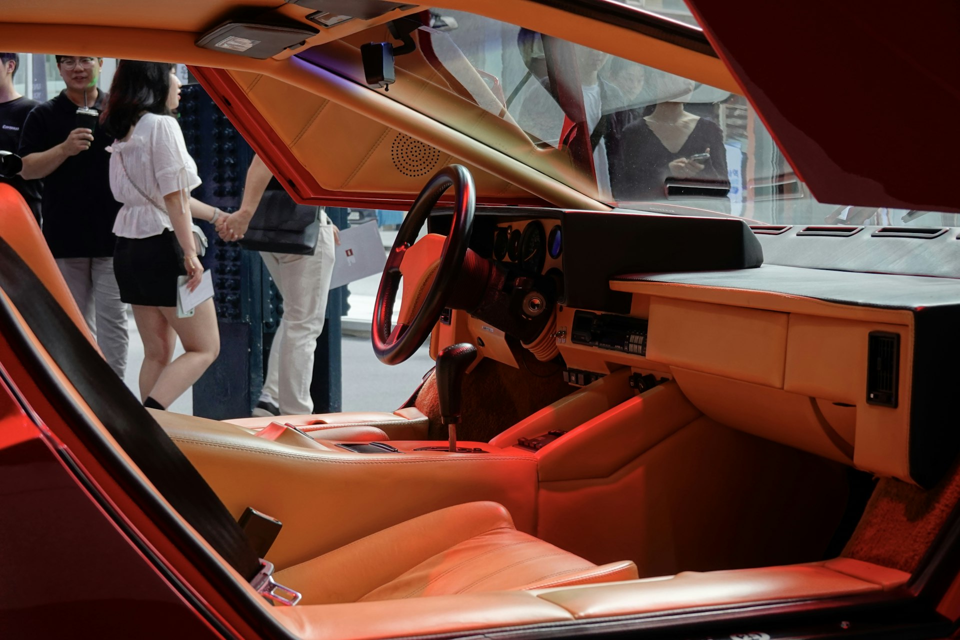 the interior of a car with people standing around