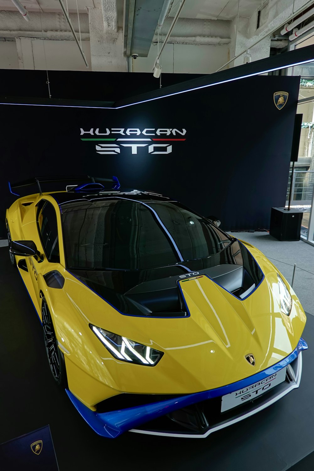 a yellow sports car on display in a showroom