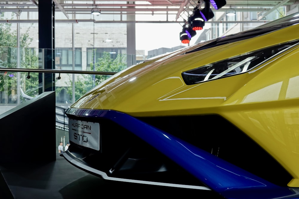 a yellow and blue sports car parked in a garage