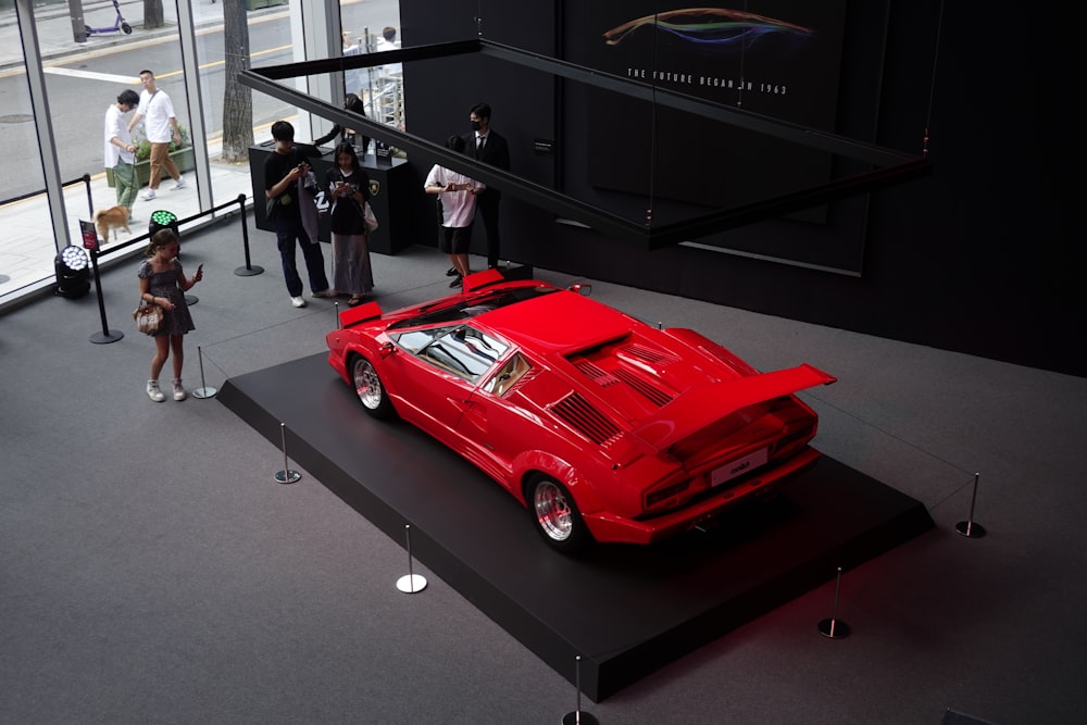 a red sports car on display in a museum