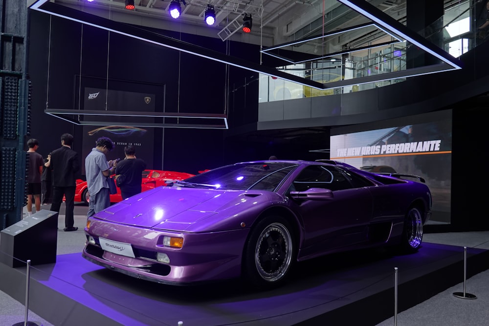a purple sports car on display at a car show