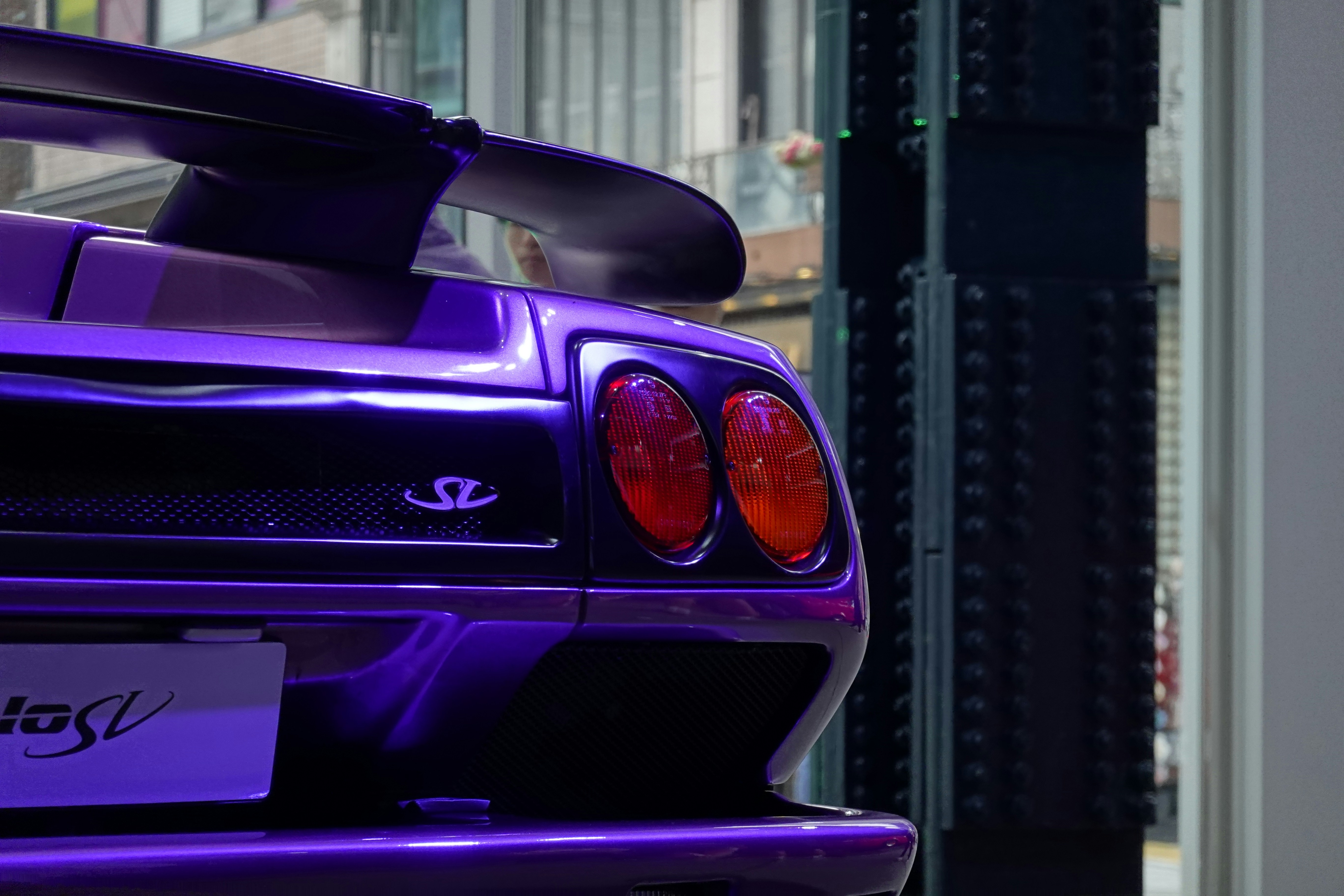 a purple sports car parked in front of a building