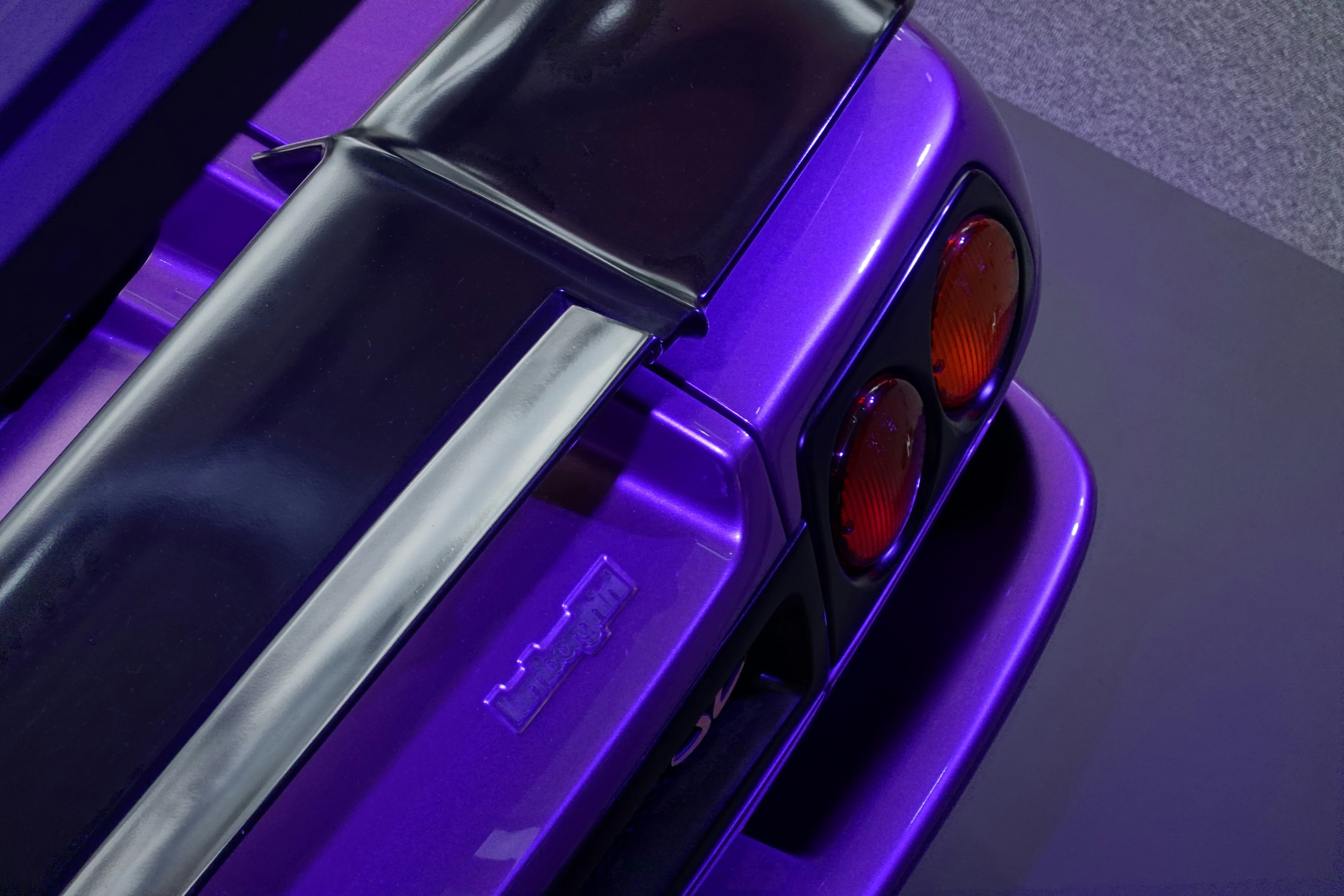 a close up of the tail lights of a purple car