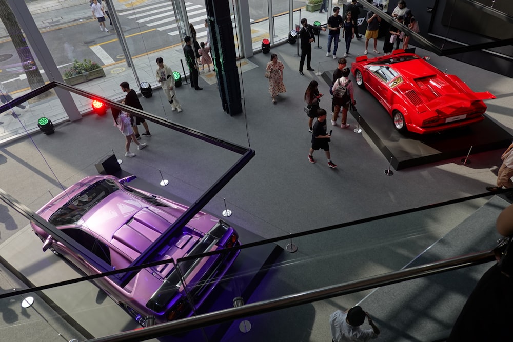 a group of people standing around a purple car