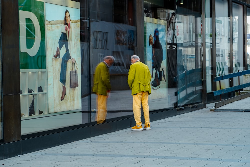 a couple of men standing next to each other in front of a store