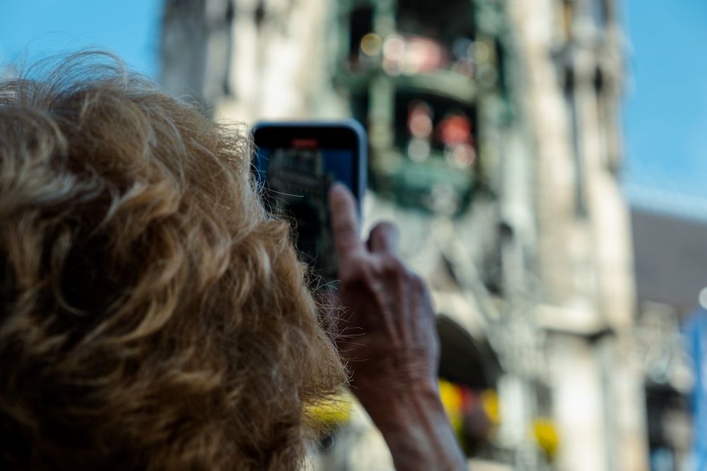 a person taking a picture of a building with a cell phone