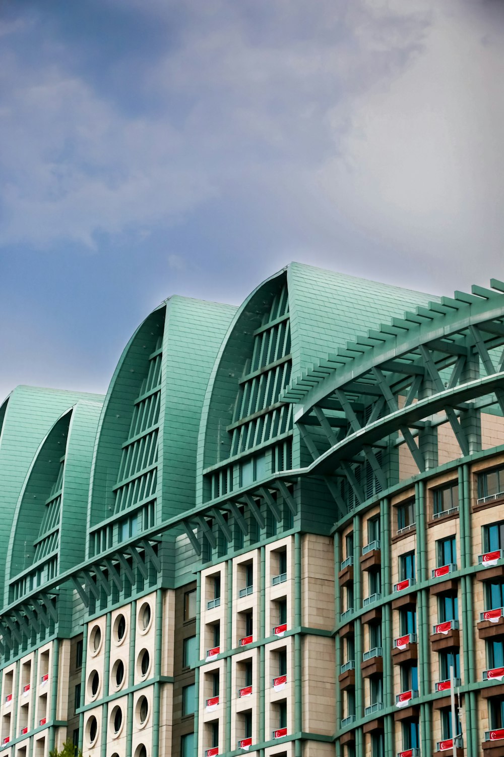 a row of green and white building with a clock on the front