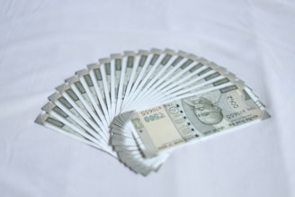 Several 500 Indian rupee banknotes arranged in a fanned pattern on a white background.