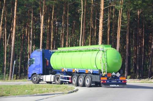 a large green tanker truck driving down a road