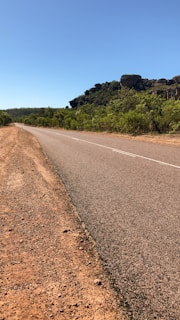 A freshly paved road stretching into the horizon under a clear blue sky, symbolizing progress and commitment.