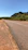 Photo of a paved road stretching between Januária and Pandeiros under a bright blue sky.