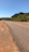 Photo of a paved road stretching between Januária and Pandeiros under a bright blue sky.