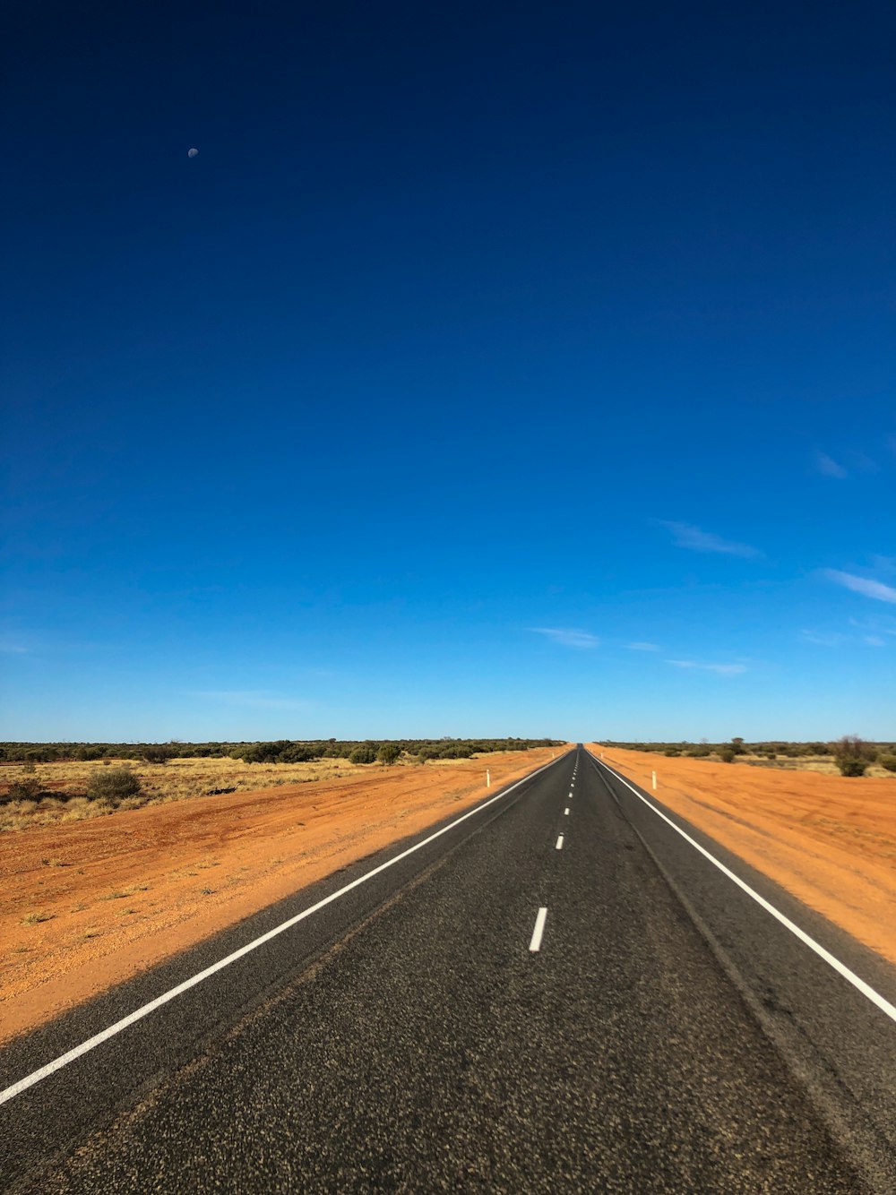 an empty road in the middle of the desert