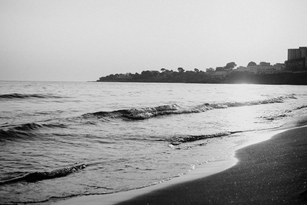 a black and white photo of the ocean and a beach