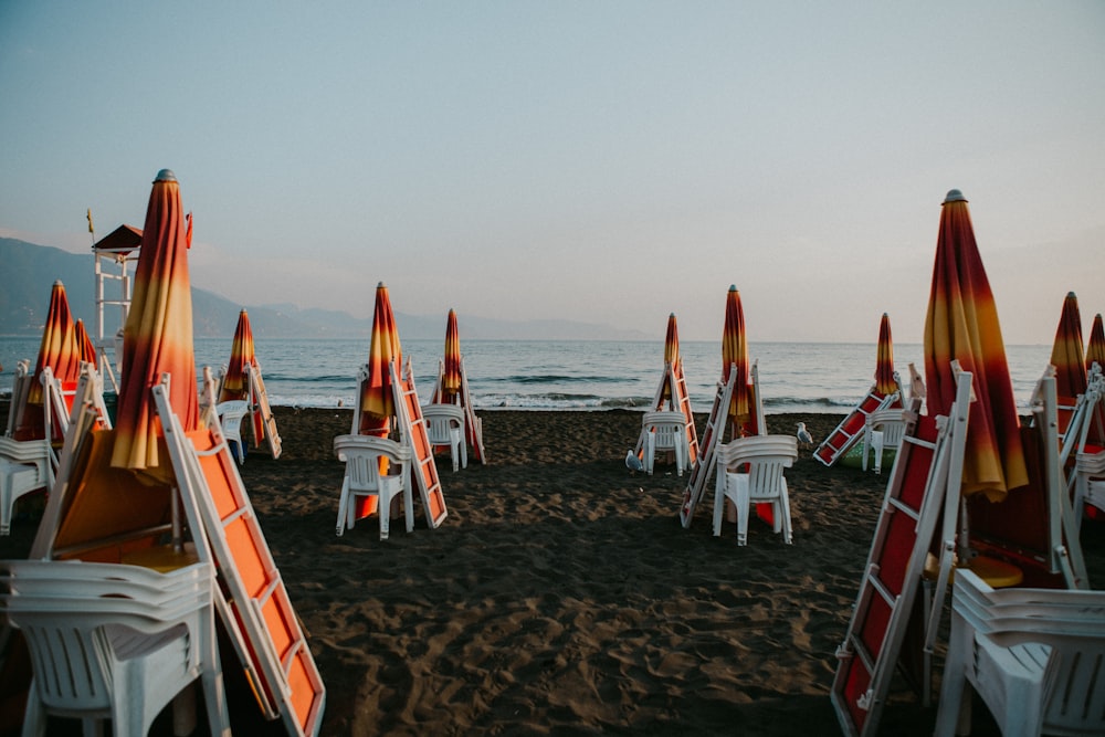 a bunch of chairs and umbrellas on a beach