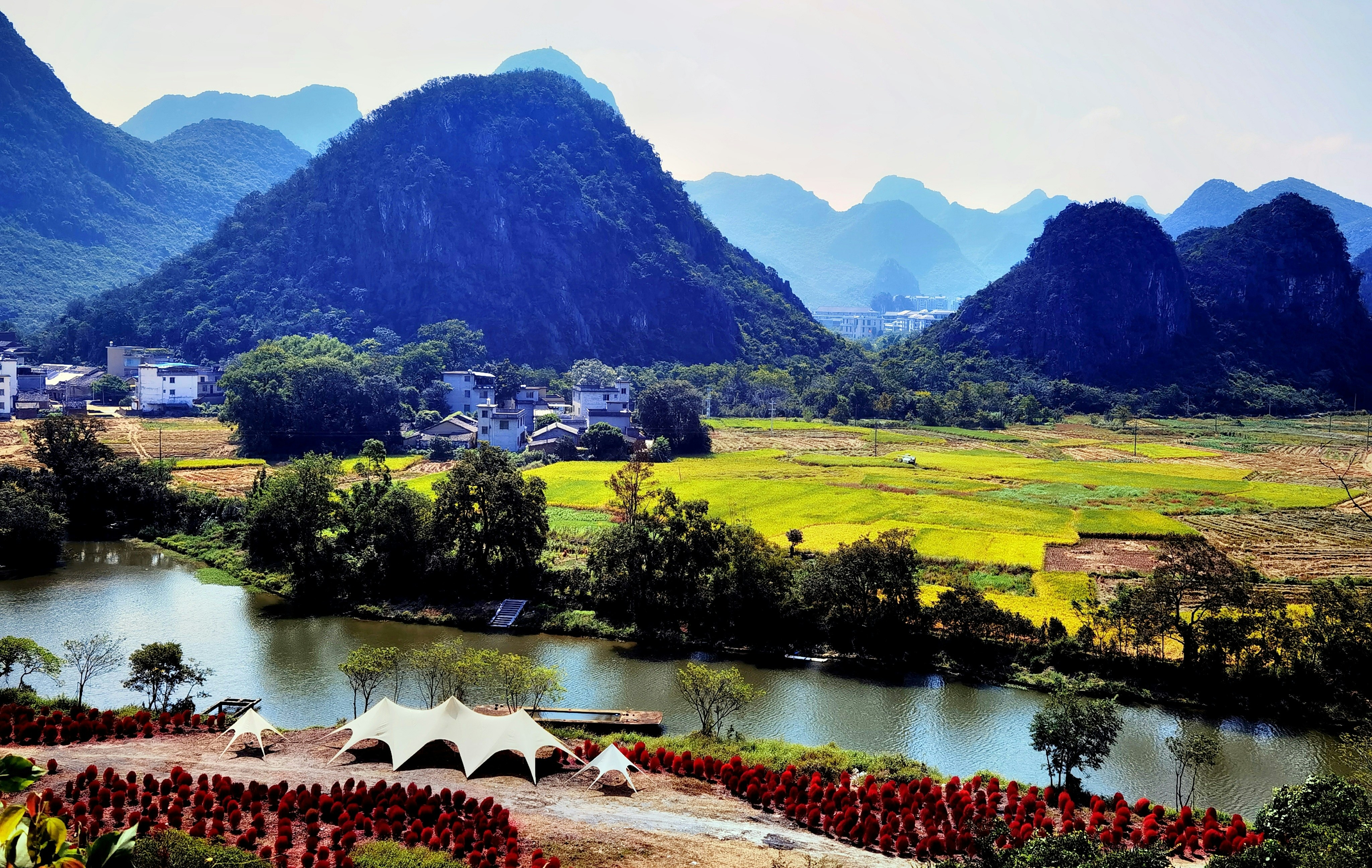 a scenic view of a valley with mountains in the background