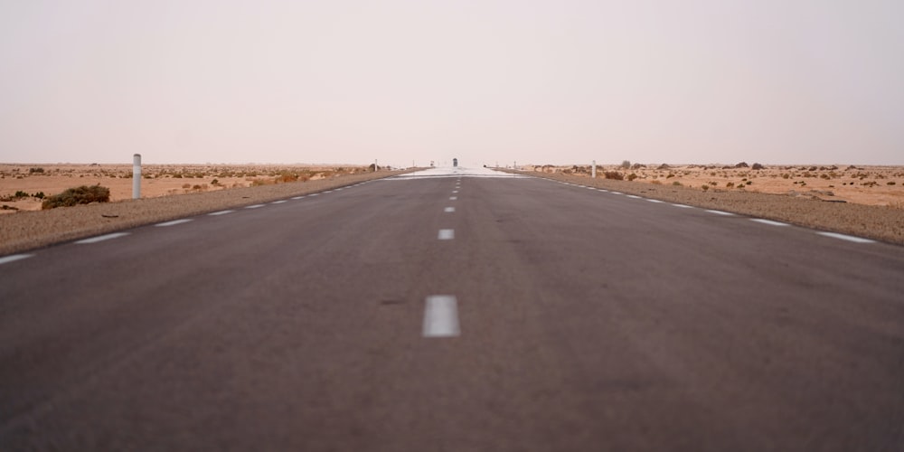 an empty road in the middle of the desert