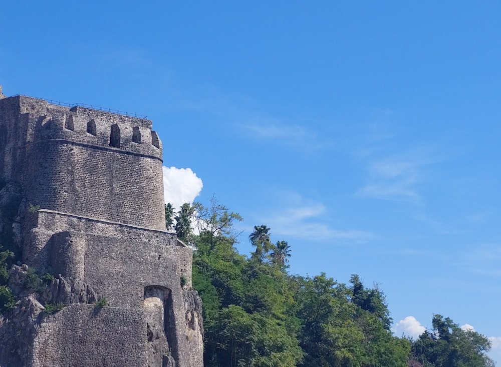 una gran torre de piedra situada en lo alto de una exuberante ladera verde