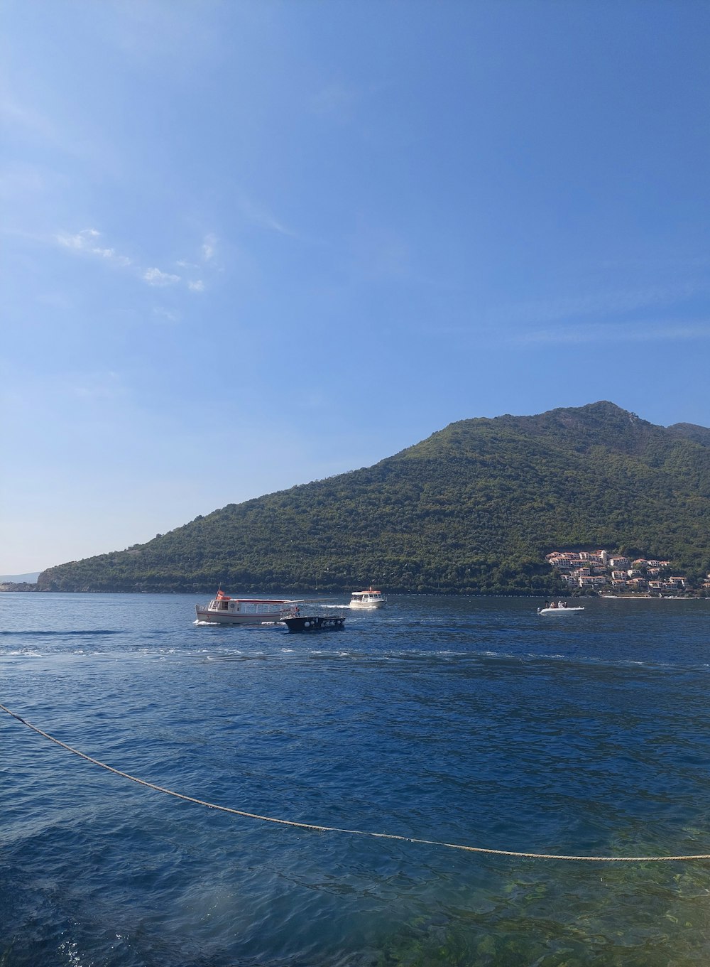 a boat traveling on a body of water near a mountain