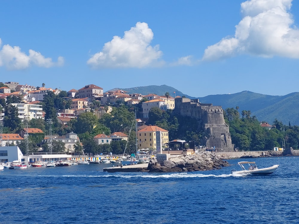 a boat traveling down a body of water near a city