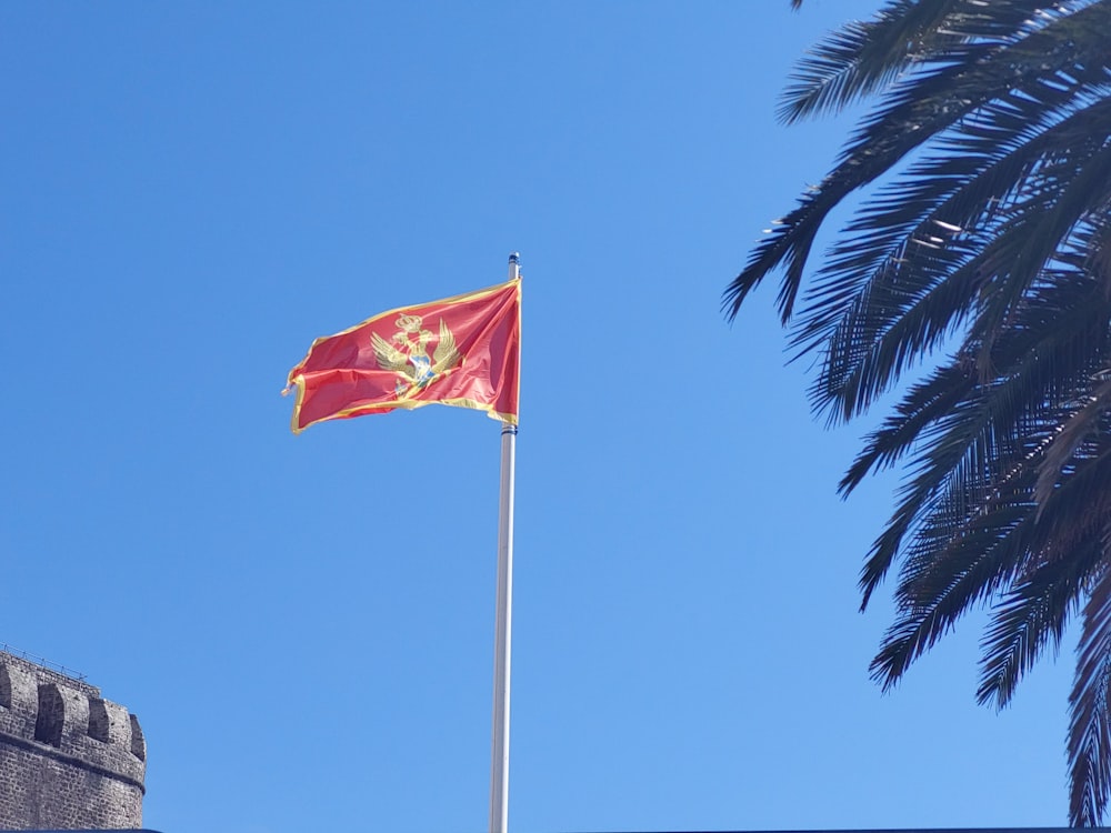 a red and yellow flag flying on top of a building