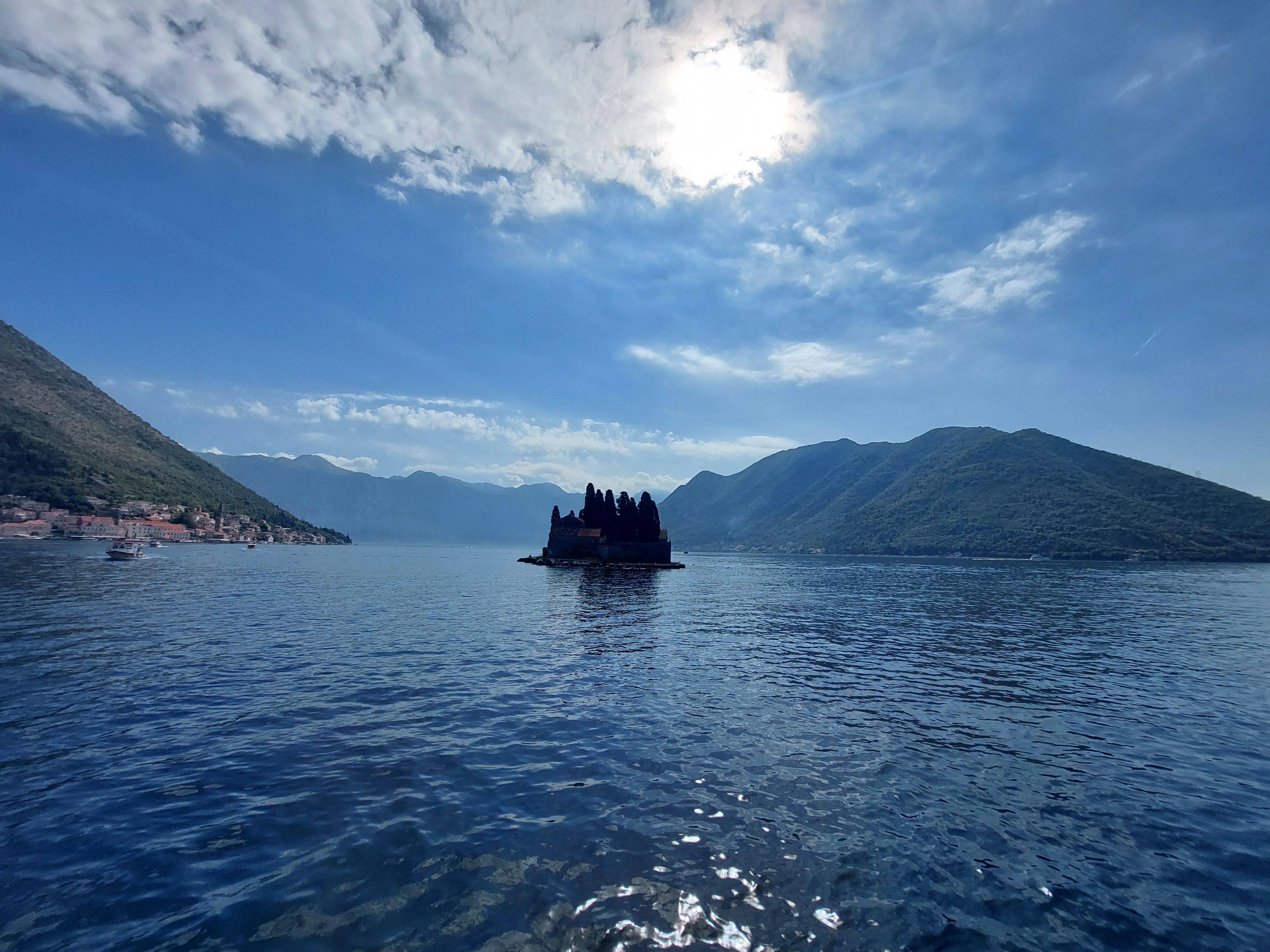 a large body of water with a small island in the middle of it, 